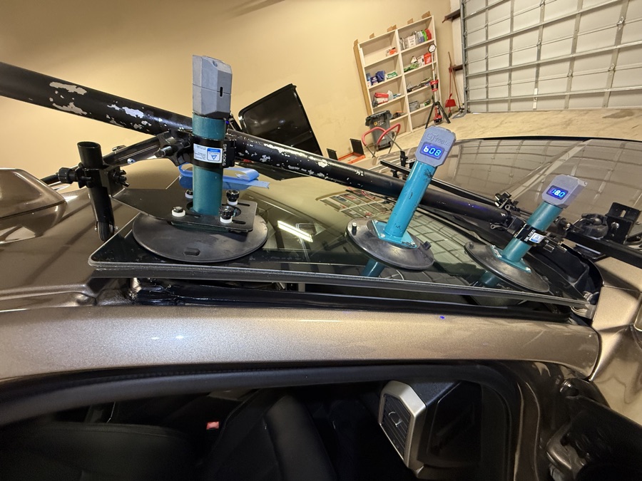 Technician setting a new windshield with suction tools at South Texas Auto Glass